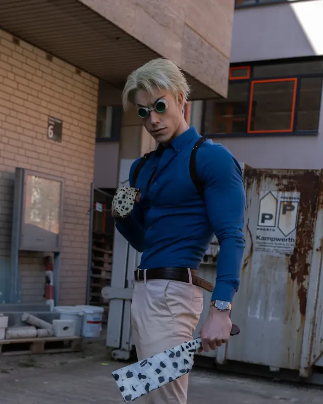 Character portrait in a blue shirt with goggles and a handcrafted prop weapon.