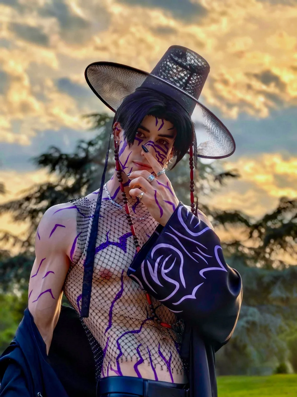 Bodypaint cosplay portrait at sunset with a wide black hat and purple markings.