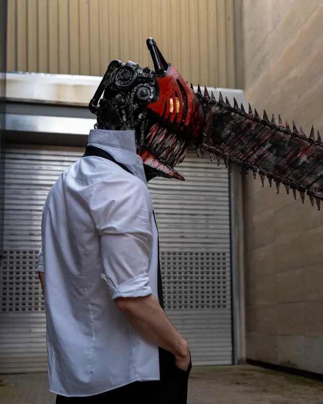 Side-view Chainsaw Man cosplay portrait with a handcrafted chainsaw helmet and white shirt.