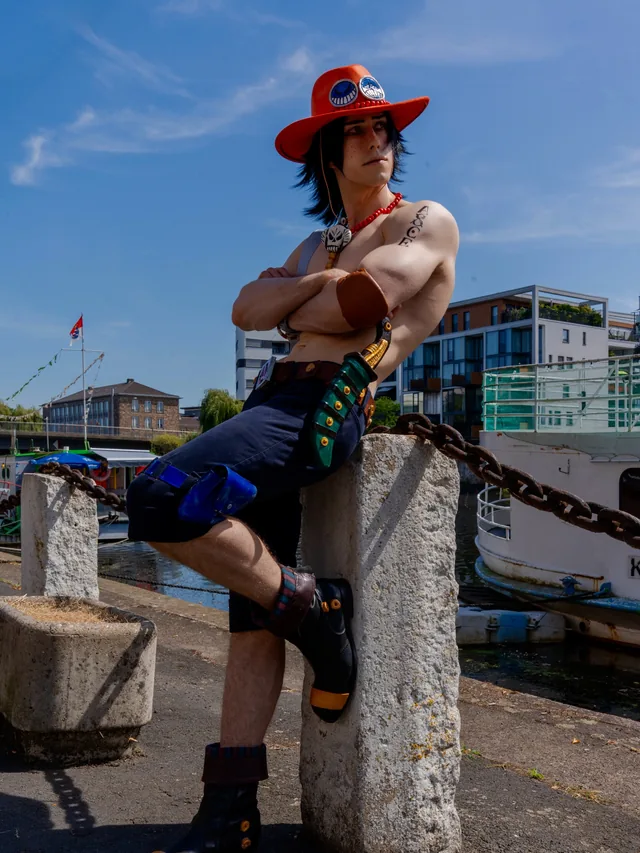 Portgas D. Ace cosplay in a harbor setting with the handmade costume and accessories.